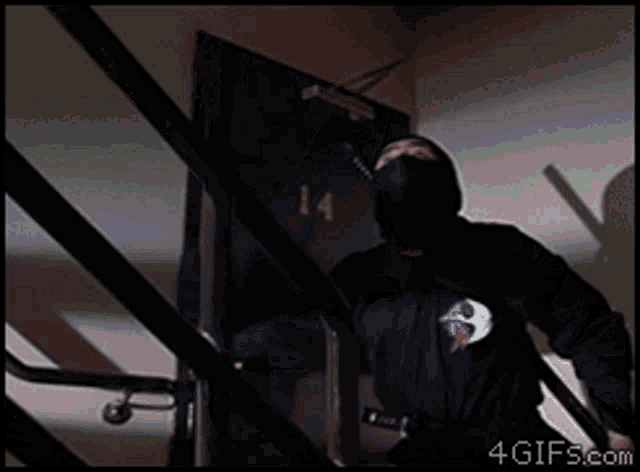 a man in a mask is walking up a set of stairs with the website 4gifs.com visible in the corner