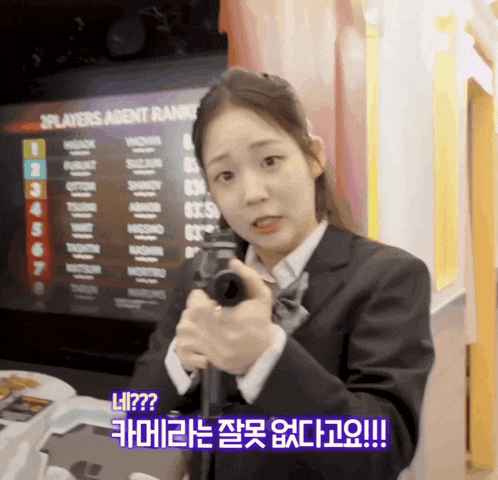 a girl in a suit holds a gun in front of a 2players agent rank screen