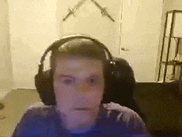 a man wearing headphones is sitting in front of a computer screen in a room .