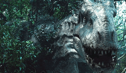a close up of a dinosaur with its mouth open in a forest