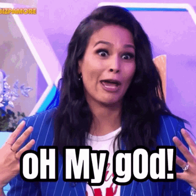 a woman in a blue suit is making a funny face and saying oh my god .