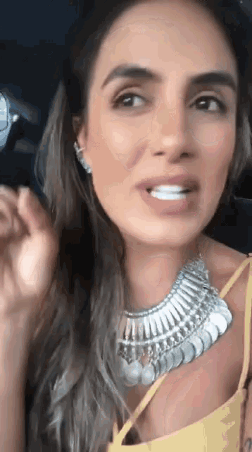 a close up of a woman wearing a necklace and earrings