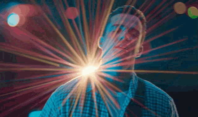 a man in a plaid shirt has a light coming out of his mouth