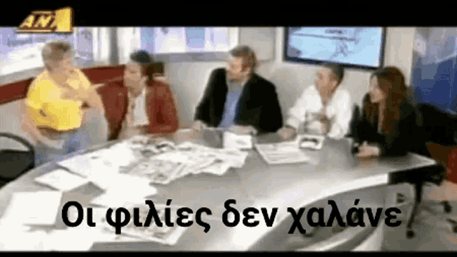 a group of people are sitting around a table with a sign that says an