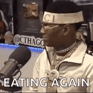 a man wearing a headband with the word gucci on it is eating again .