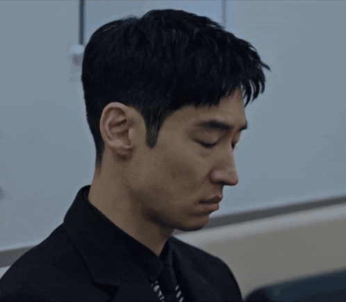 a man in a suit and tie is looking down