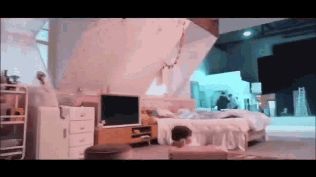 a bedroom with a bed and a television on the wall