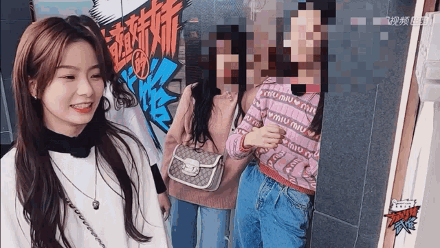 a girl wearing a sweater that says " miu miu " stands next to two other girls