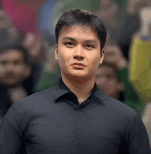 a man in a black shirt is standing in front of a crowd