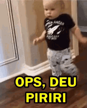 a baby is walking on a wooden floor with the words ops , deu piriri written in yellow .