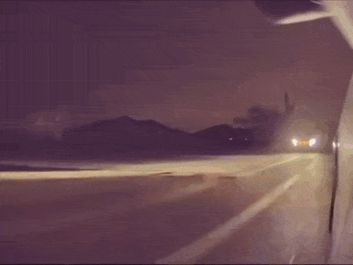 a car is driving down the road at night