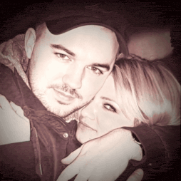 a man in a black hat is hugging a woman in a black shirt