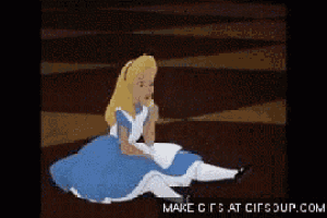 alice from alice in wonderland is sitting on the ground eating a cookie .