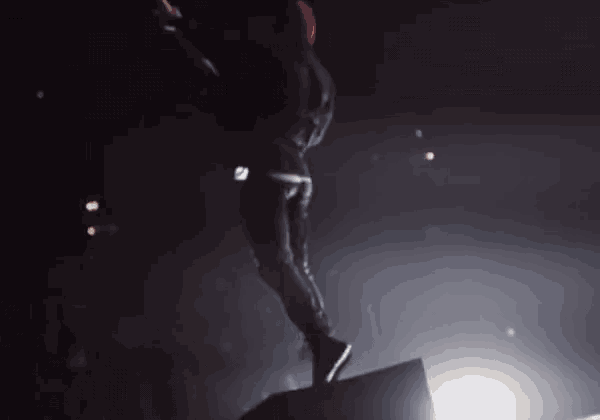 a man in a red hat is jumping in the air on stage