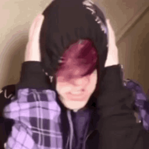 a person with pink hair is wearing a purple plaid shirt and a black hoodie .