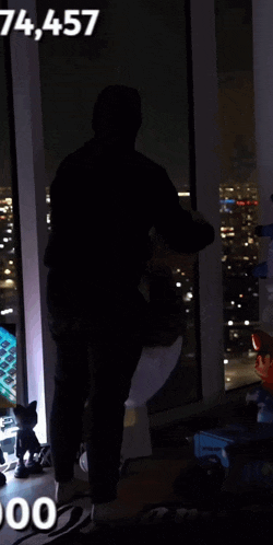 a person is standing in front of a window with the number 74,457 on it