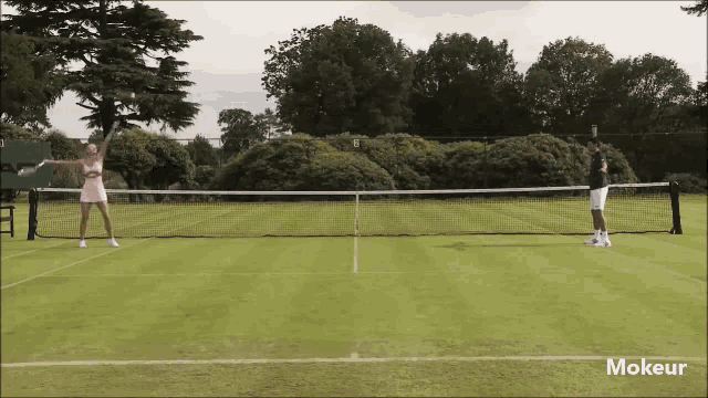 a man and a woman are playing tennis on a court with the words mokeur on the bottom