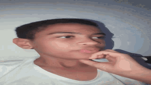 a young boy with his hand on his chin