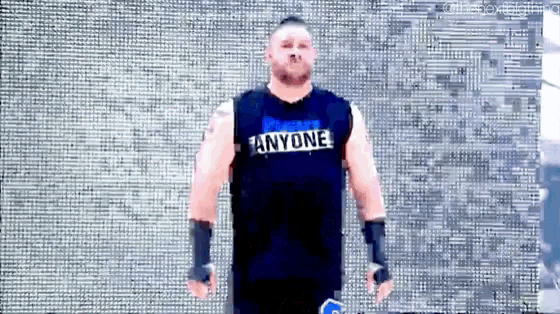a wrestler wearing a shirt that says anyone on it
