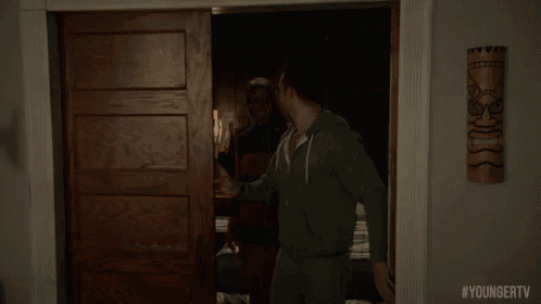 a man is standing in a doorway with #youngertv written on the bottom of the screen