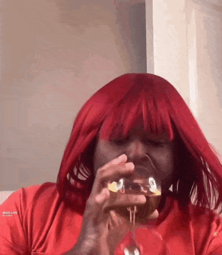 a woman with red hair drinking from a glass