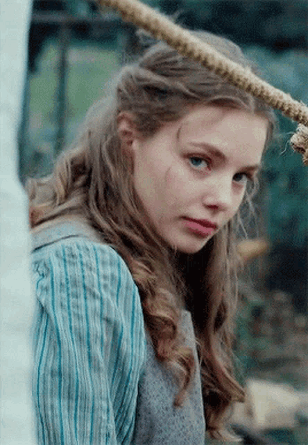 a close up of a woman 's face with a rope hanging from her head