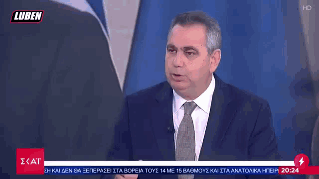 a man in a suit and tie is talking on a television screen with the words luben on it