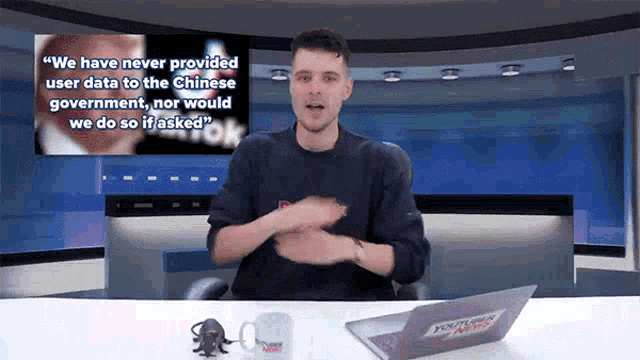 a man sitting at a desk with a laptop and a mug that says youtube news