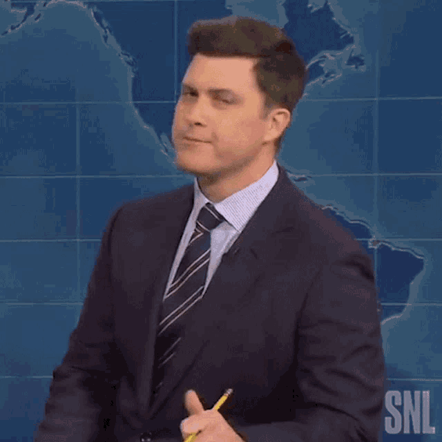 a man in a suit and tie is holding a yellow pencil .