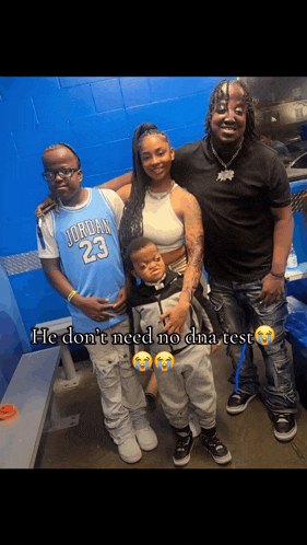 a man in a jordan 23 jersey is posing for a picture with his family .