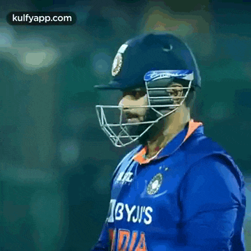 two cricket players are hugging each other in a stadium .