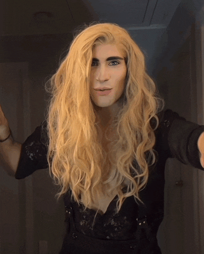 a man with long blonde hair wearing a black top