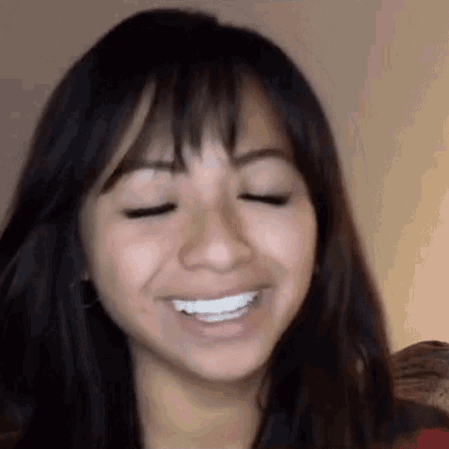 a close up of a woman smiling with her eyes closed .