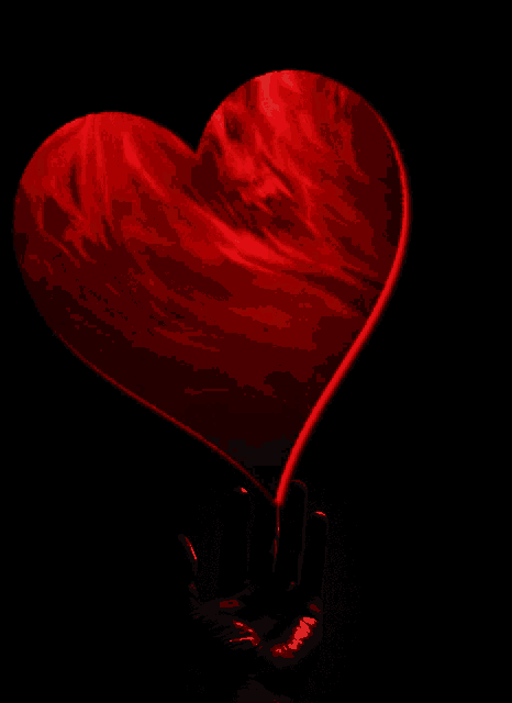a hand is reaching out towards a large red heart