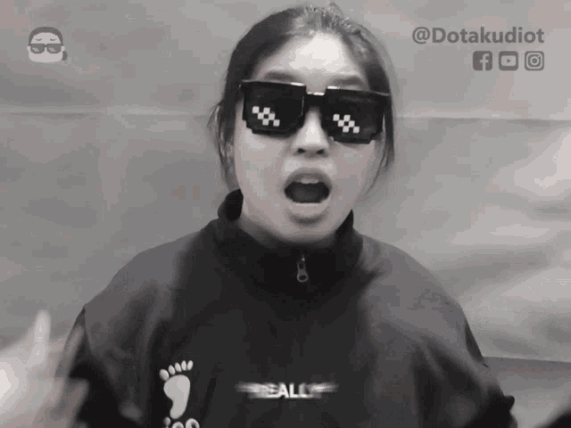 a woman wearing sunglasses and a black shirt that says ball