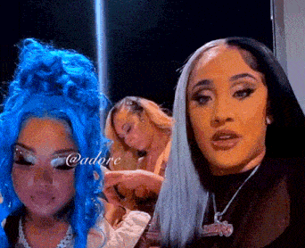 a woman with blue hair is standing next to another woman with blonde hair