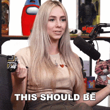 a woman sitting in front of a microphone with the words this should be written on her face