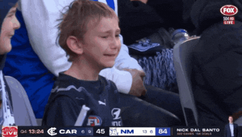 a young boy is crying while watching a game on fox sports