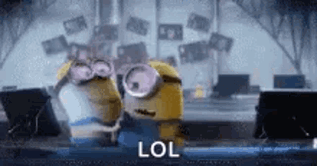 a couple of minions are hugging each other in a room with a lol sign .