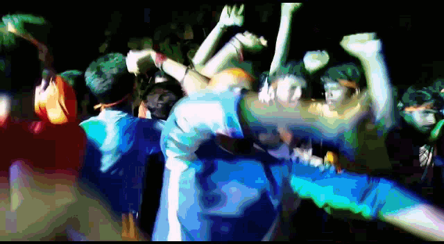 a group of people are dancing in a dark room