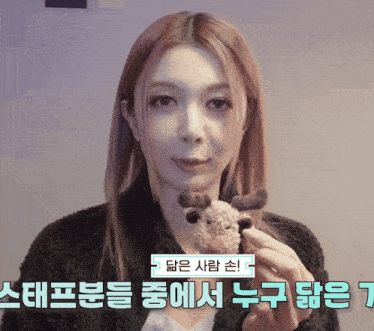 a woman is holding a stuffed reindeer with korean writing on it