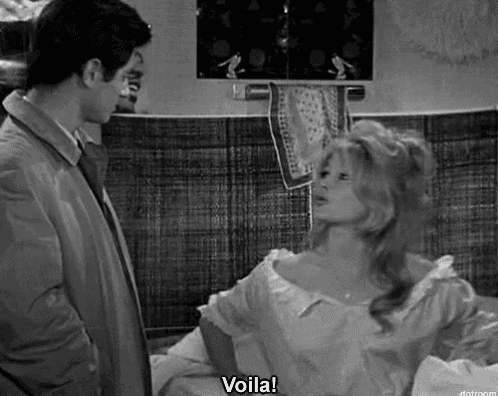a man and a woman are standing next to each other in a black and white photo and the woman is saying voila .