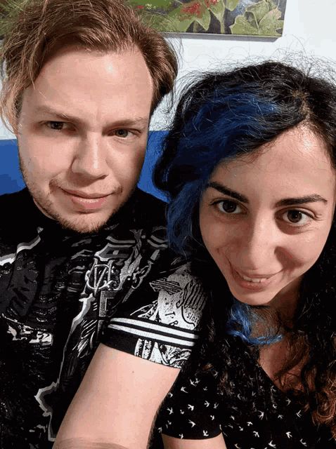 a man and a woman are posing for a picture and the man is wearing a black shirt that says ' samurai '