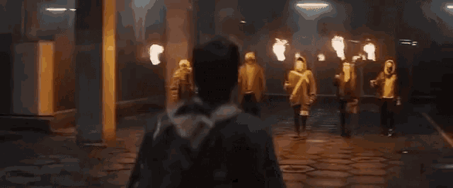 a man is walking through a dark room holding a torch .