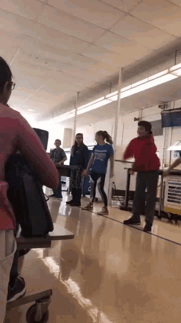 a girl in a blue shirt stands in a line with other kids