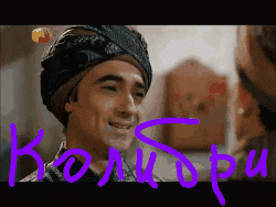 a man wearing a turban is smiling in front of a purple word
