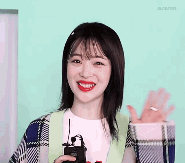 a girl with a ring on her finger holds a microphone and smiles
