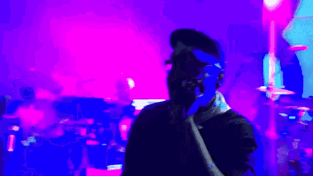 a blurry picture of a person in a dark room with purple lights