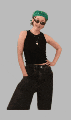 a woman wearing sunglasses and a green bandana is standing with her hands on her hips