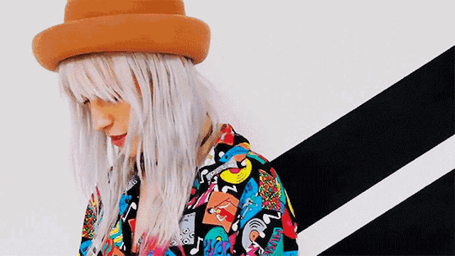 a woman wearing a hat and a colorful shirt that says ' snoopy ' on it